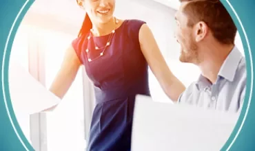 A woman smiling at a man in an office setting