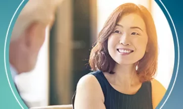 Woman smiling during a conversation in a professional setting.