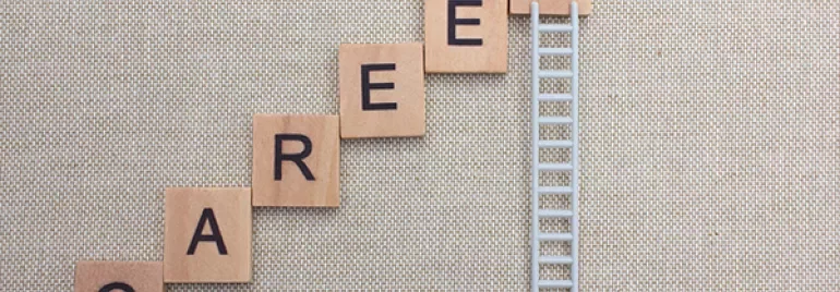 Scrabble tiles spelling 'CAREER' arranged like stairs next to a ladder.