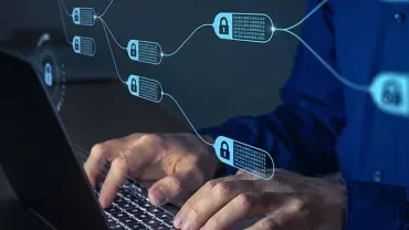 Person typing on laptop with digital blockchain links and padlocks in the foreground.