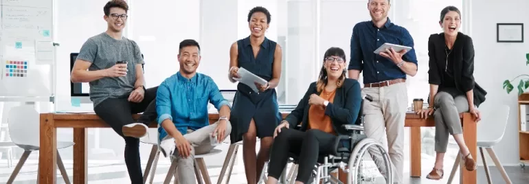 A diverse group of colleagues smiling in a modern office setting.