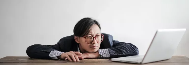 Person in glasses resting head on hands