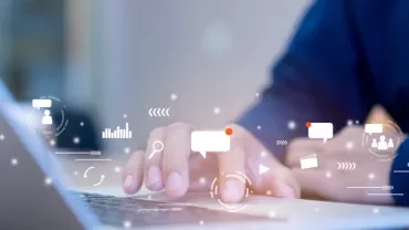 Person typing on laptop with digital icons overlay