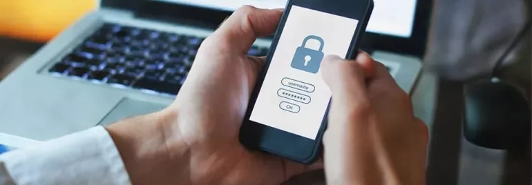 Person holding a phone with a lock screen for secure login.