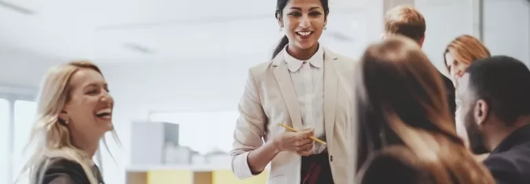 Smiling businesswoman leading a meeting with colleagues in an office.