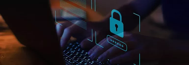 Hands typing on a laptop with a digital lock hologram