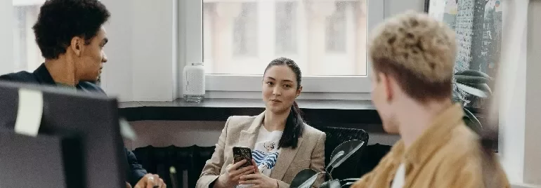 Three colleagues having a discussion in a modern office.