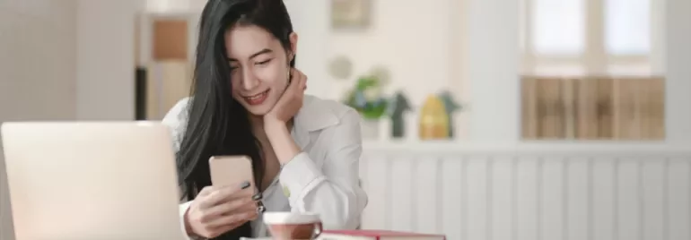 Woman smiling while looking at her phone