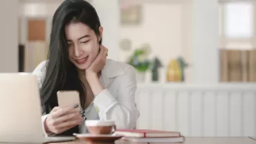 Woman smiling while looking at her phone