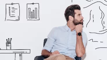 Man sitting in front of a wall with drawn office and landscape elements.